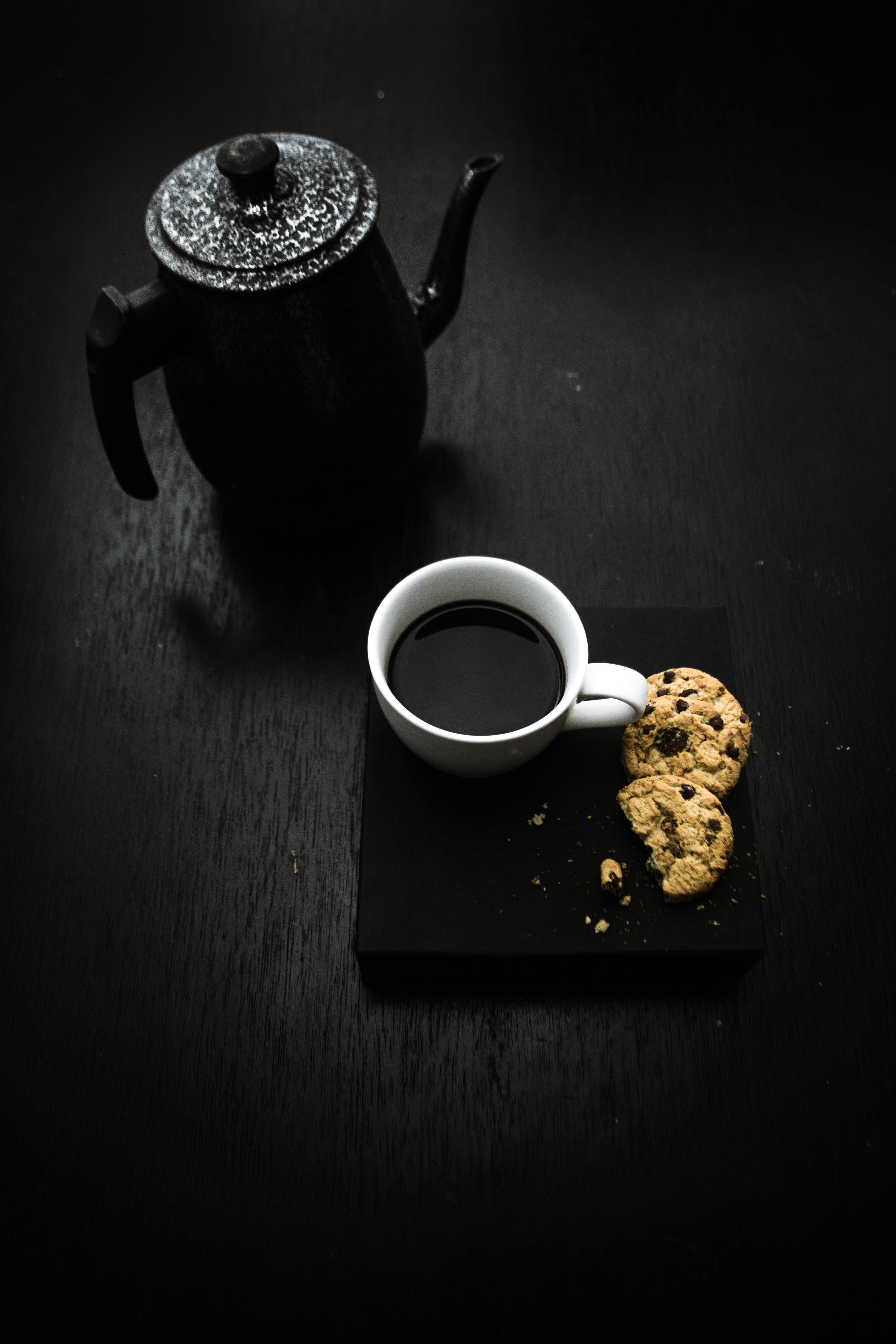 teapot with black tea like liquide and cookies